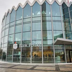 Nowoczesna rotunda Banku Polskiego z przeszkloną fasadą, w tle Pałac Kultury.