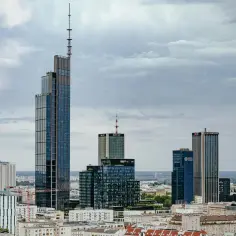 Warszawski drapacz chmur, najwyższy budynek w Warszawie, góruje nad panoramą miasta, otoczony innymi nowoczesnymi wieżowcami.