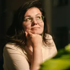 Kobieta w okularach zamyślona, zastanawia się nad odrzuceniem spadku.