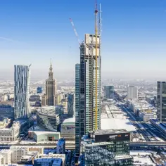 Warszawa zimą. W budowie najwyższy budynek w Europie, otoczony innymi wieżowcami i ośnieżonym miastem.