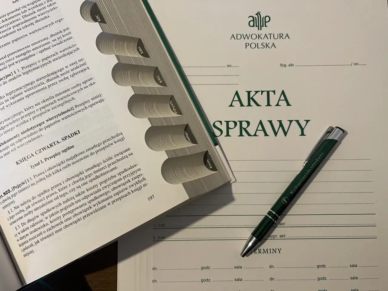 Księga spadkowa z dobrodziejstwem inwentarza, dokumenty prawne i długopis z pieczęcią Wielkopolskiej Izby Adwokackiej.
