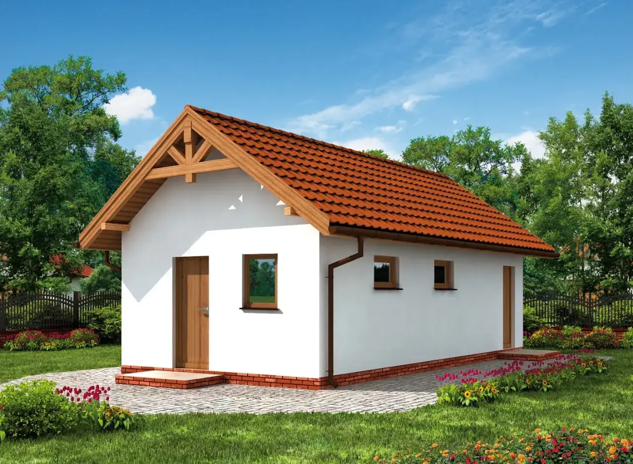 Nowy, biały budynek gospodarczy z drewnianymi elementami i czerwoną dachówką, otoczony zielenią i kwitnącymi rabatami.