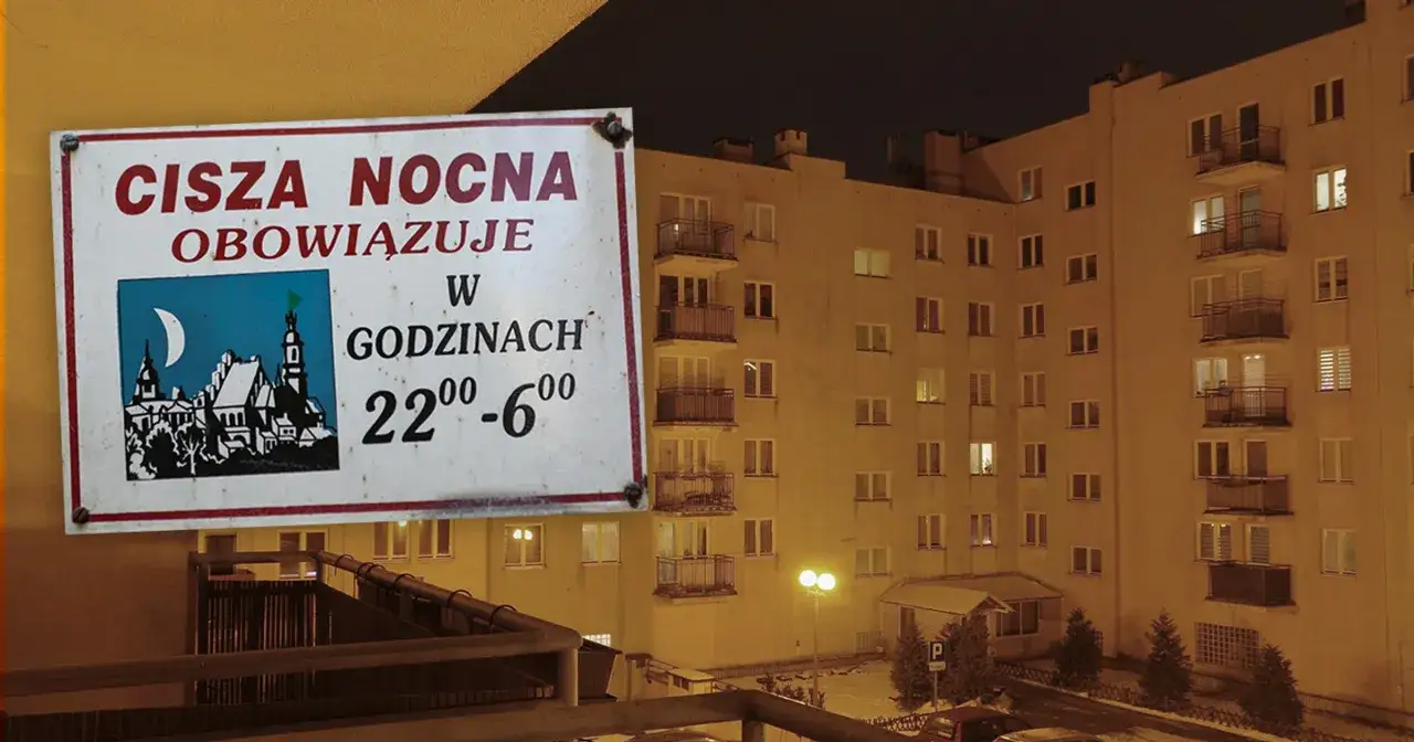 Tabliczka informuje o ciszy nocnej w bloku od 22:00 do 6:00. W tle widać nocny widok budynku mieszkalnego.